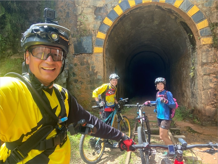 Riders at the historic Cisneros railway tunnel on the Paisa MTB Adventure, Antioquia