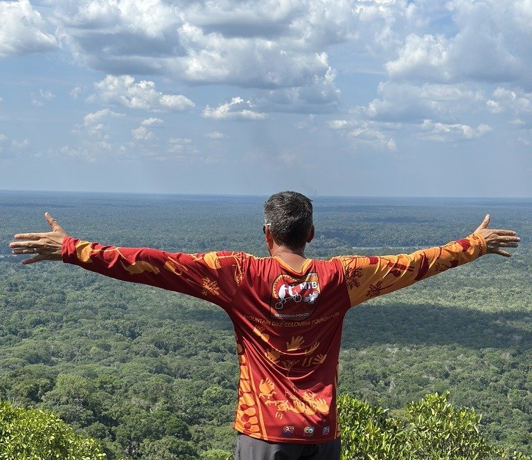 Rider looking out over the Colombian Amazon jungle canopy from a tepui