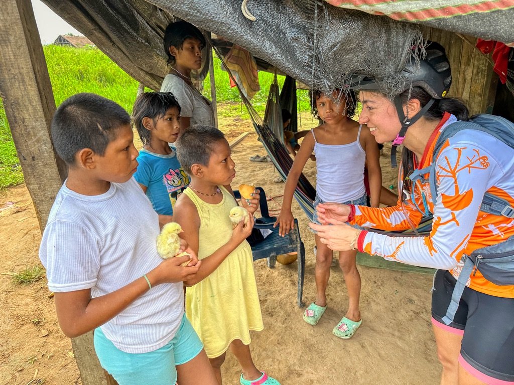 Nukak children receiving baby chicks delivered by expedition riders