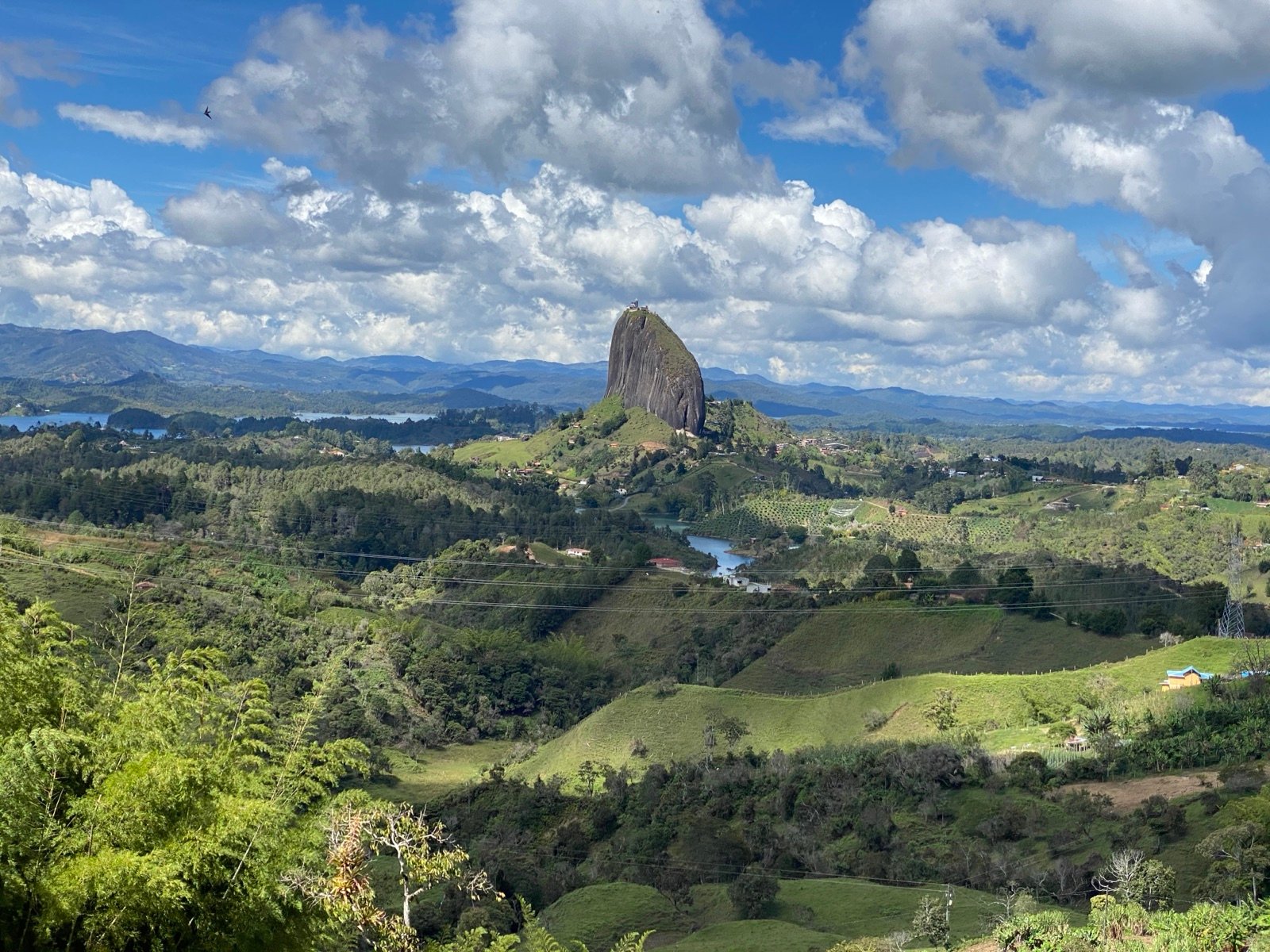 Panorama over farmland and the reservoir towards La Piedra del Peñol from a ridge above Guatapé
